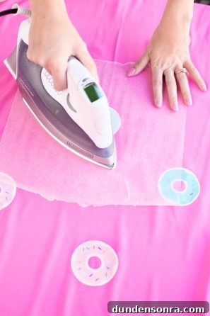 Someone ironing on pink fabric