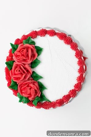 A cake with red frosted flowers on it