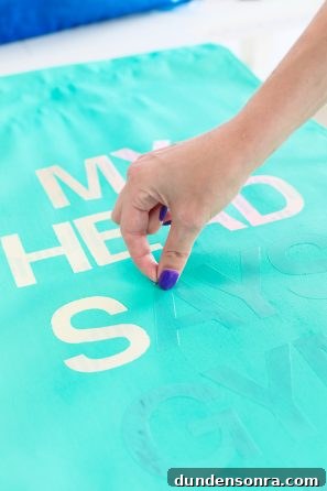 Someone putting letters on aqua fabric