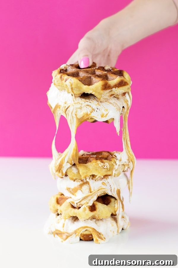 Someone holding waffle sandwiches  