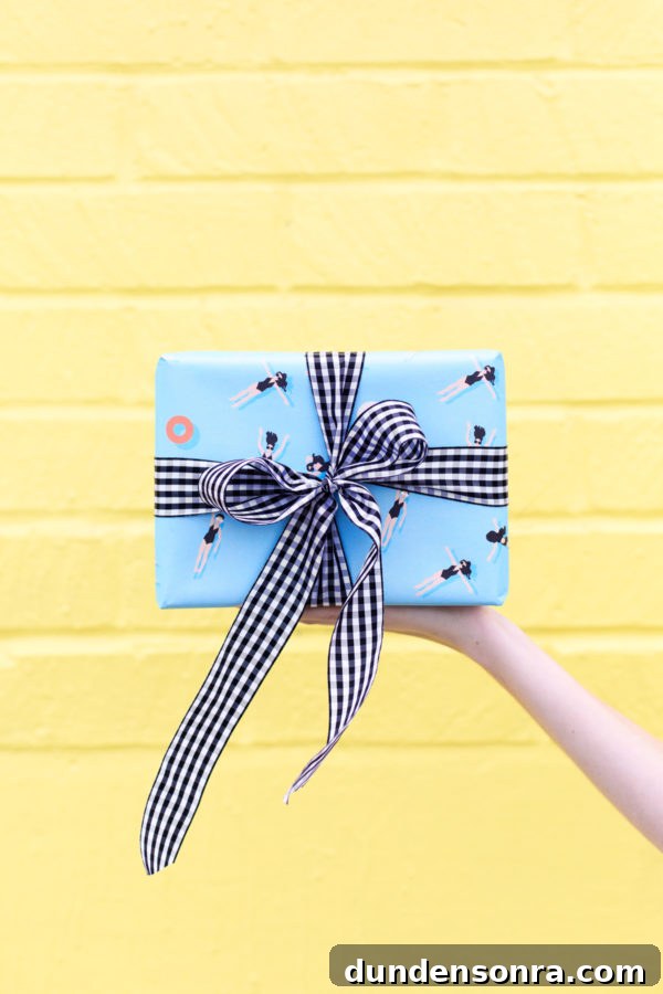 Someone holding a present in front of a yellow wall