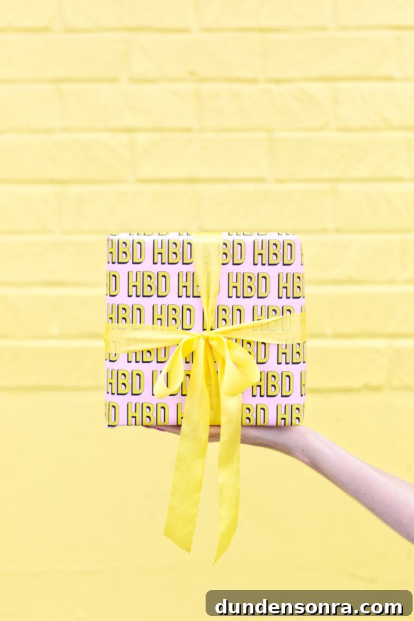 Someone holding a present in front of a yellow wall