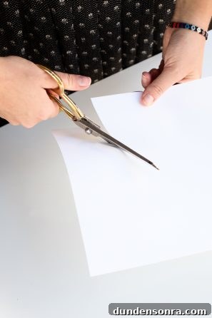 Someone cutting a white paper