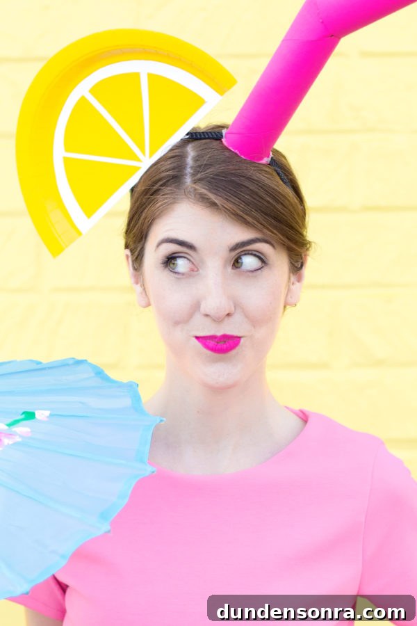 A woman in a pink shirt standing in front of a yellow wall