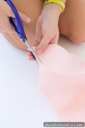 Someone cutting pink fabric