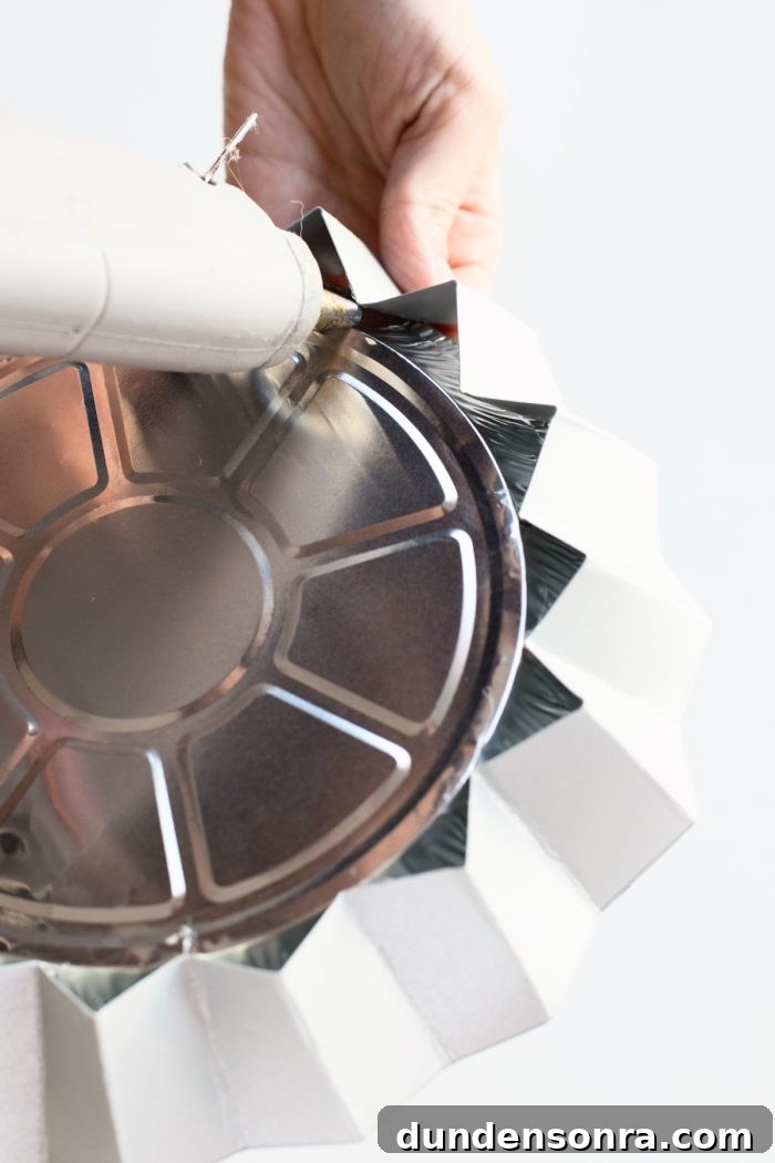 Someone gluing a tin circle
