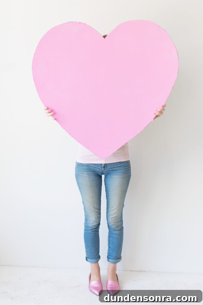 A woman holding a giant pink heart