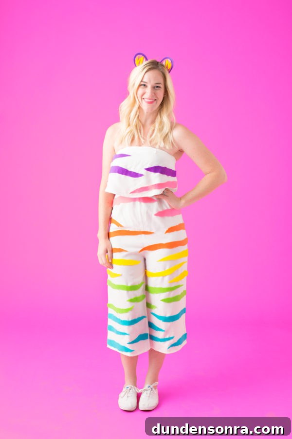A girl wearing a white romper with rainbow stripes on it