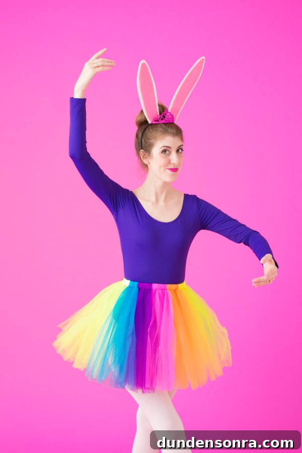 A woman wearing a purple long sleeve and rainbow tutu 