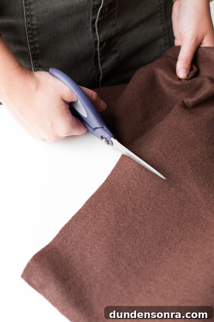 Easy Hot Dog Costume Someone cutting brown fabric with scissors