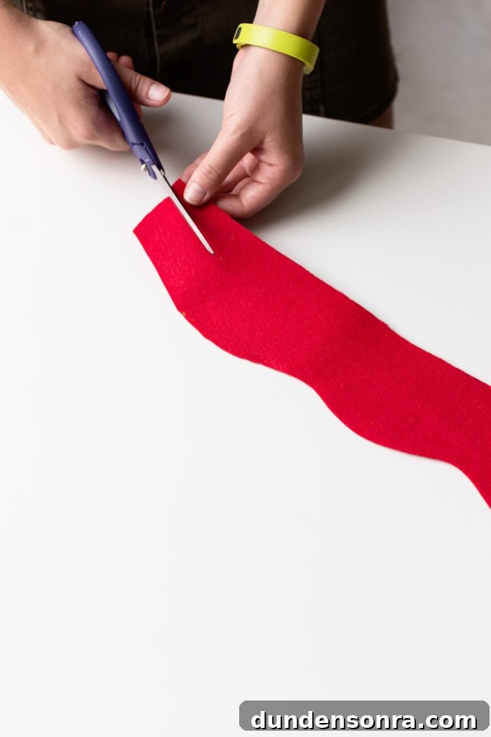 Hot Dog Outfit Hand cutting a piece of red felt.
