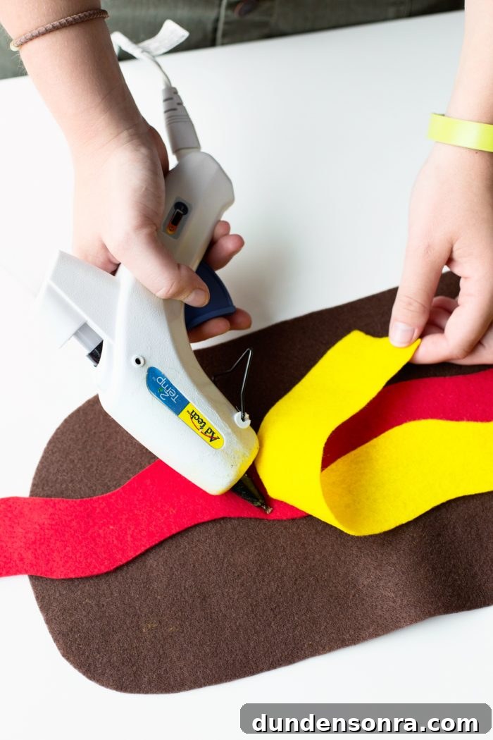 Easy Hot Dog Outfit Someone gluing yellow felt to brown and red felt.