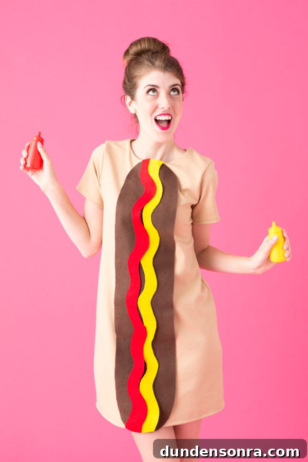 Hot Dog Halloween Costume A woman dressed up as a hot dog holding a bottle of ketchup and a bottle of mustard.