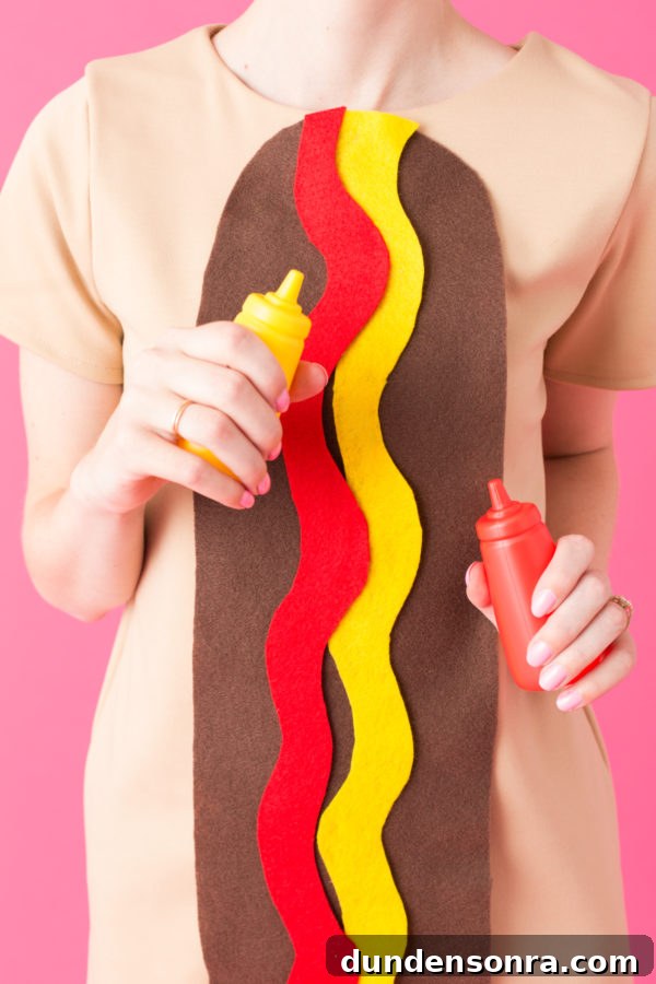 DIY Food Costumes A woman dressed as a hot dog and holding ketchup and mustard.