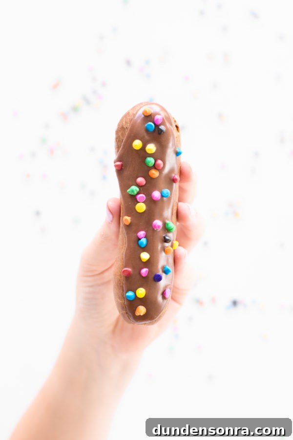 Someone holding a chocolate eclair