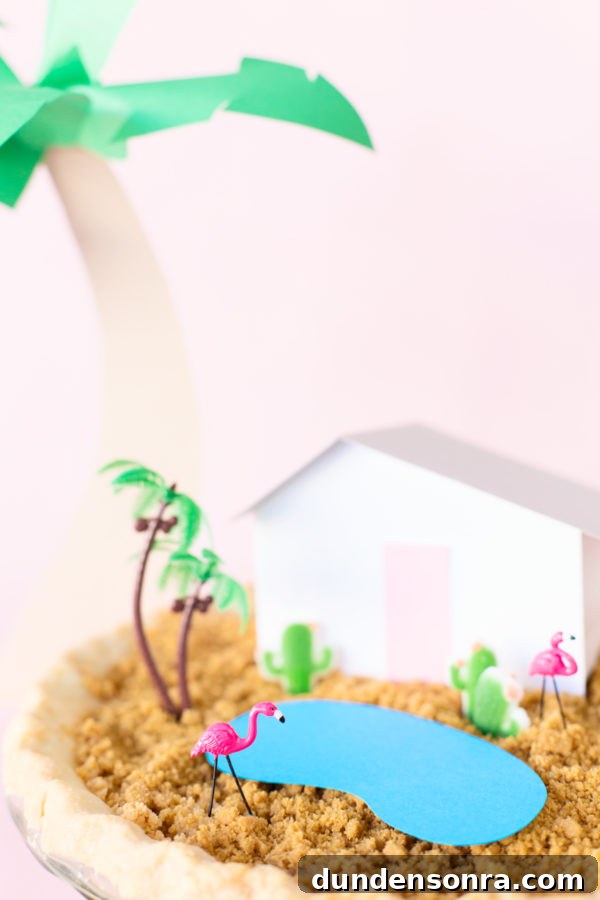 A pie with a house and fake palm trees on it