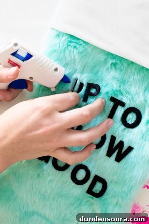 Someone gluing letters onto green fur