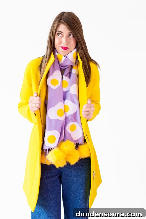 A woman wearing a purple egg scarf and yellow jacket