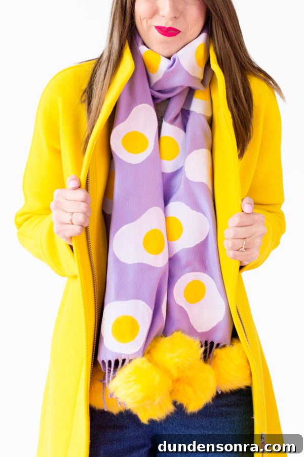 A person wearing a purple egg scarf and a yellow jacket