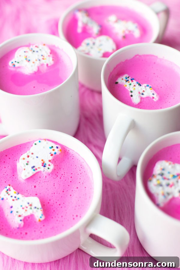 A bunch of mugs with a pink liquid and animal marshmallows 