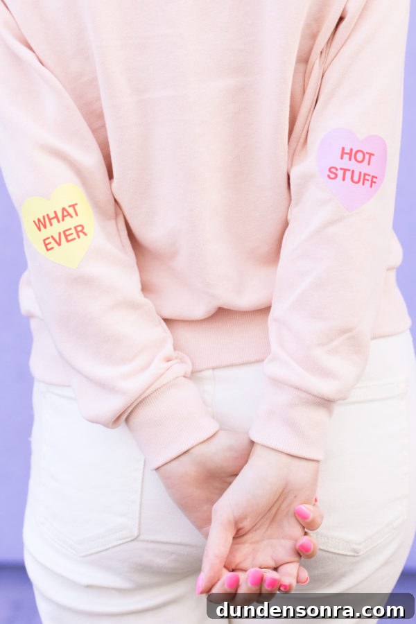 Conversation Heart Pattern Sweatshirt with Stylish Elbow Patches 4 A pink crewneck with heart patches