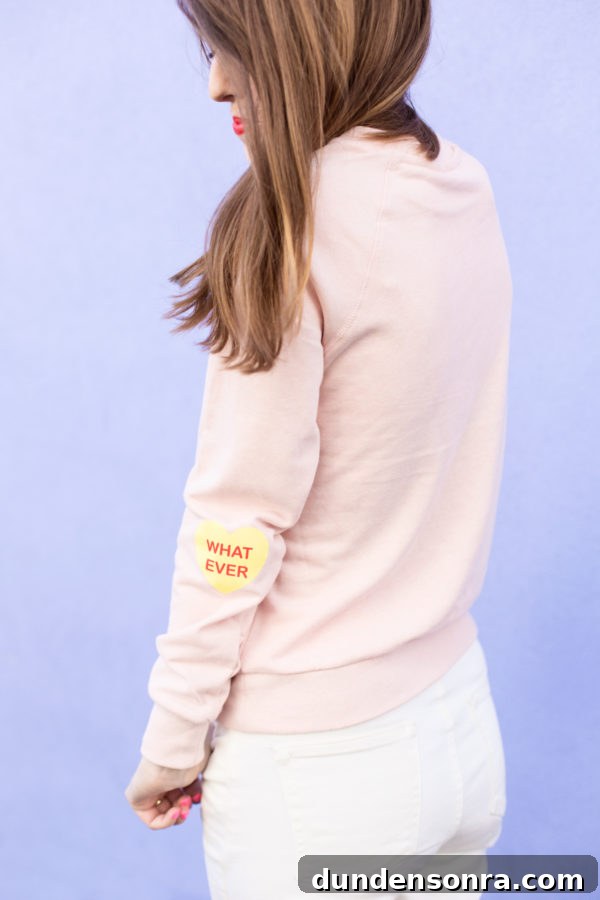Conversation Heart Pattern Sweatshirt with Stylish Elbow Patches 9 A pink crewneck with heart patches