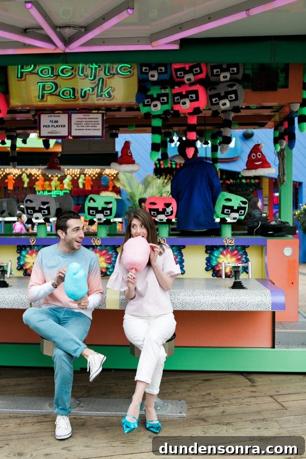 A man and a woman sitting and eating cotton candy