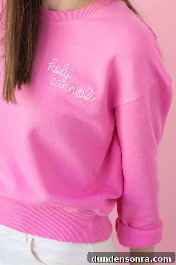 Holy cannoli embroidered on a pink crew neck