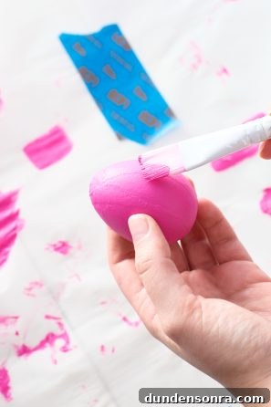 DIY Money Bag Easter Eggs: Creative Ways to Gift Cash This Easter 5 Someone painting eggs pink