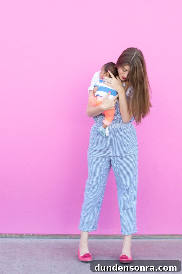 A woman standing in front of a pink wall