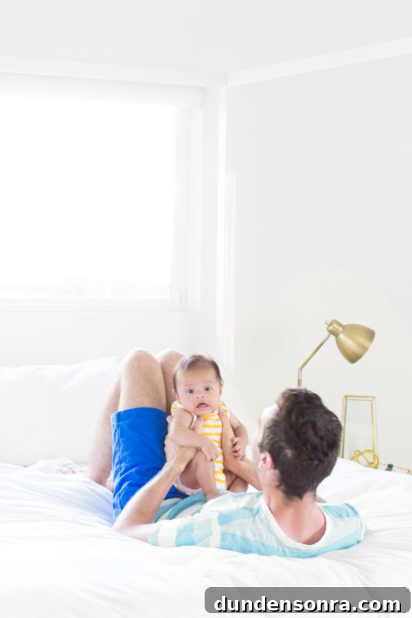 Someone holding a baby on a bed