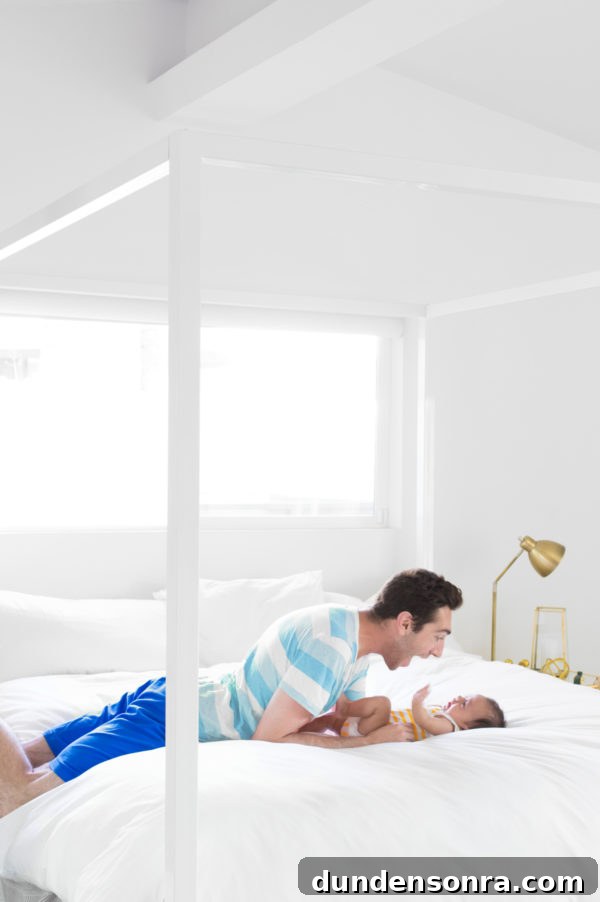 A man and a baby sitting on a bed
