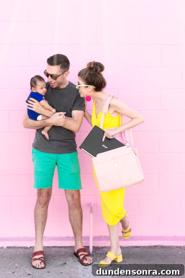 A family standing in front of a pink wall