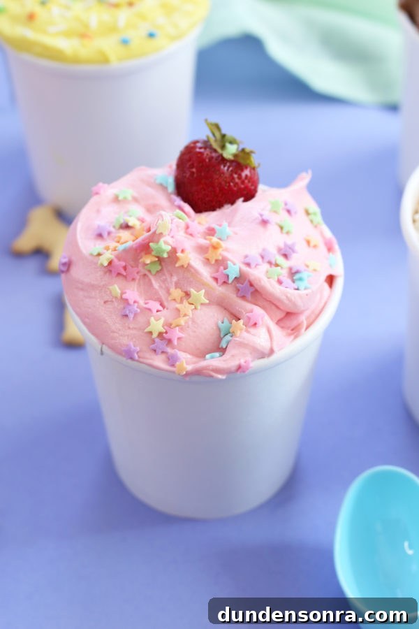 A cup with pink cream and a strawberry