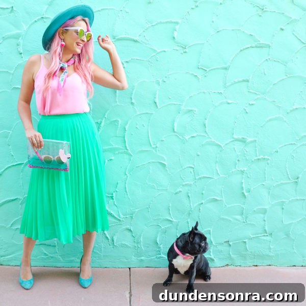 What's In My Clutch: Hot Pink Pineapple Accessories 8 A woman standing in front of a blue wall next to a dog
