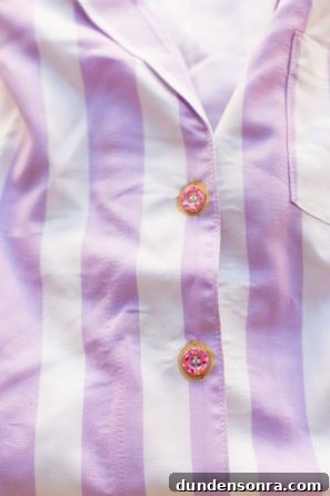 A close up of a purple and white striped shirt with buttons 