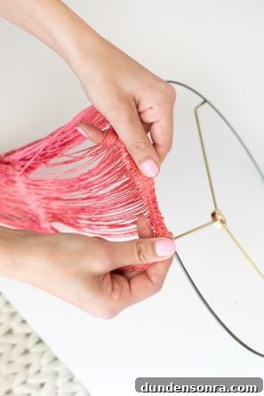 DIY Fringe Chandelier: Step-by-Step Guide to Make One at Home 4 Someone making something with pink string