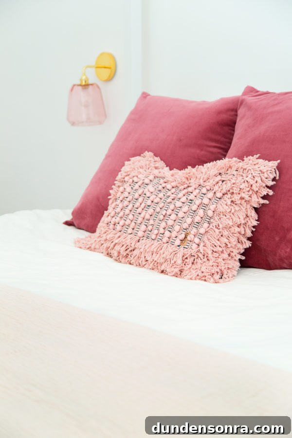 A pink pillow on a bed