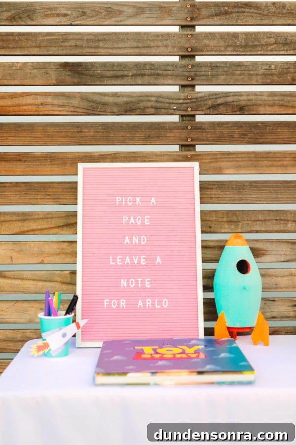 Arlo’s To Infinity and Beyond First Birthday Party Ideas 16 A pink sign with a rocket next to it