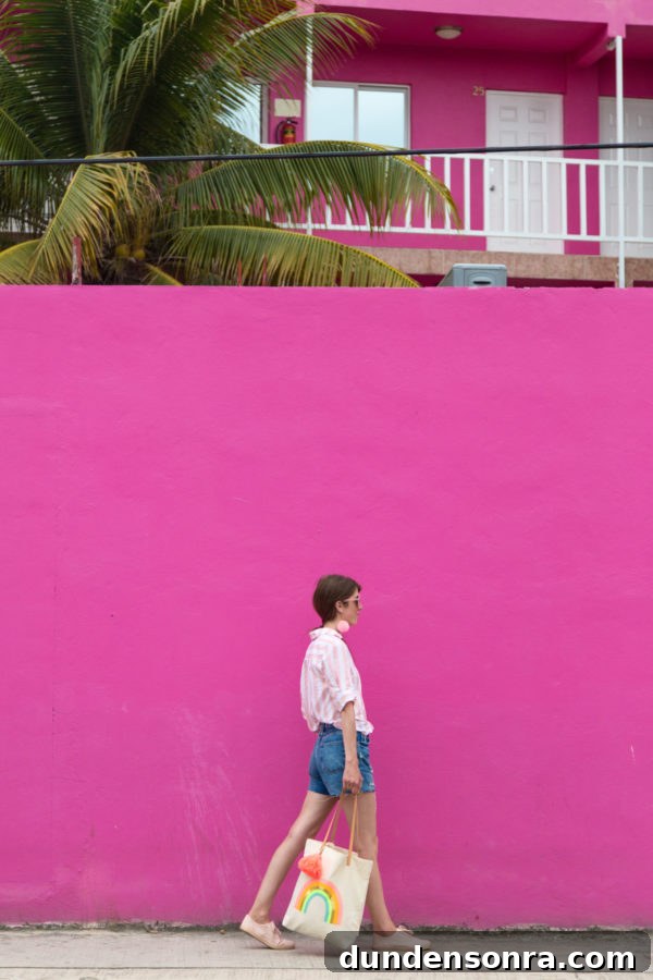 A person standing in front of a pink building