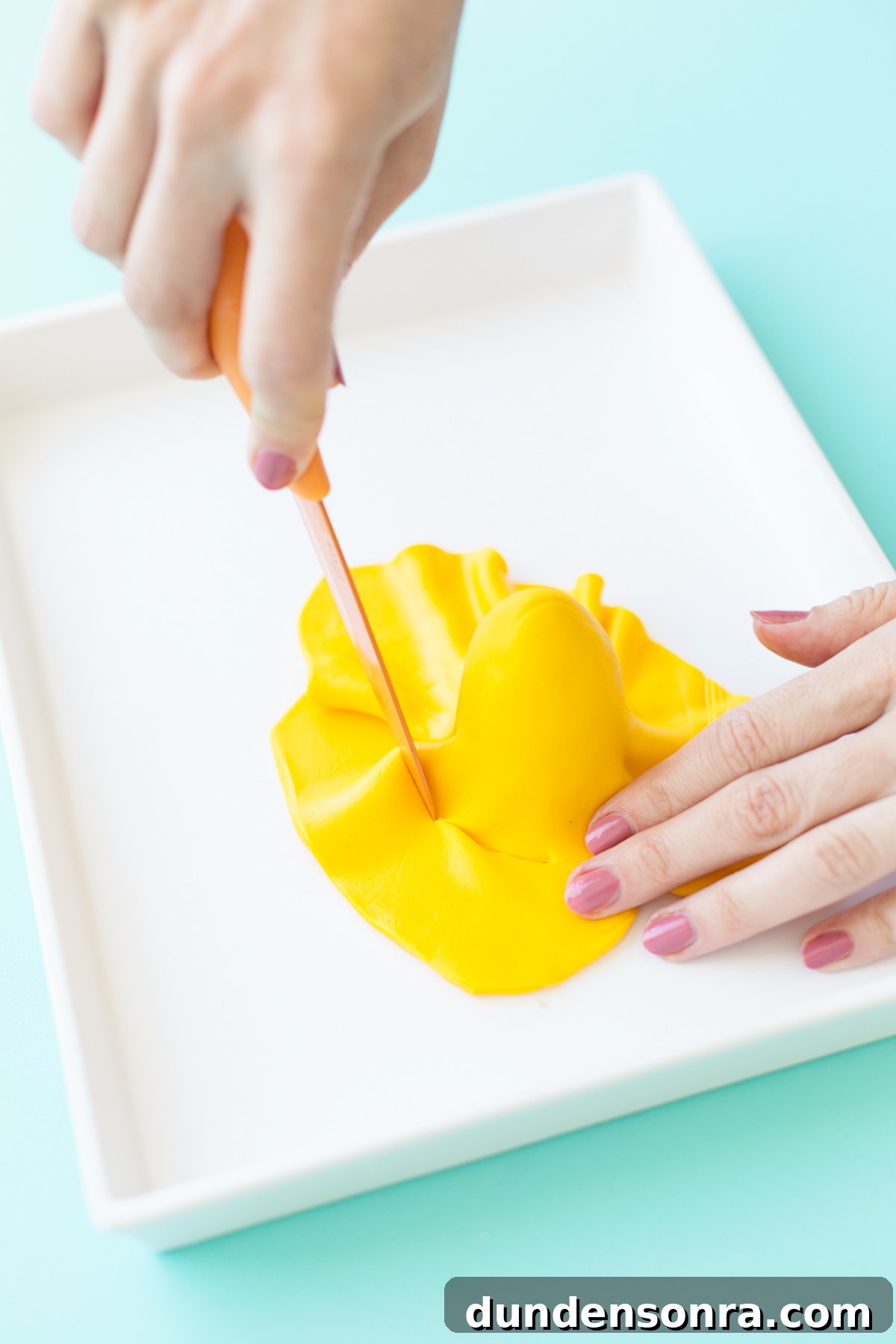 Space-Themed Cupcakes: Step-by-Step Recipe & Decorating Tips 9 Yellow fondant draped on cake pop with knife cutting it
