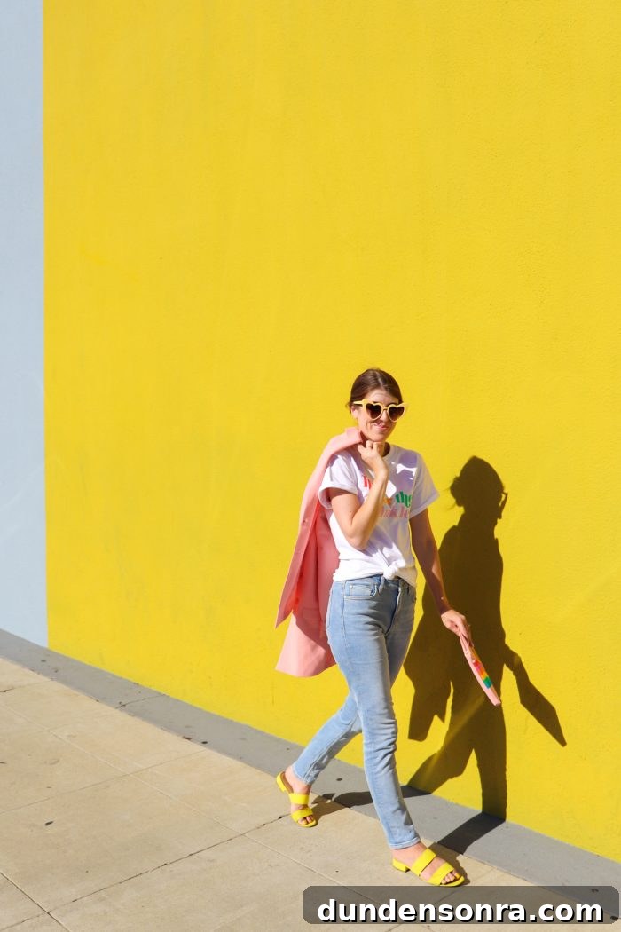 A person posing for a picture in front of a yellow wall