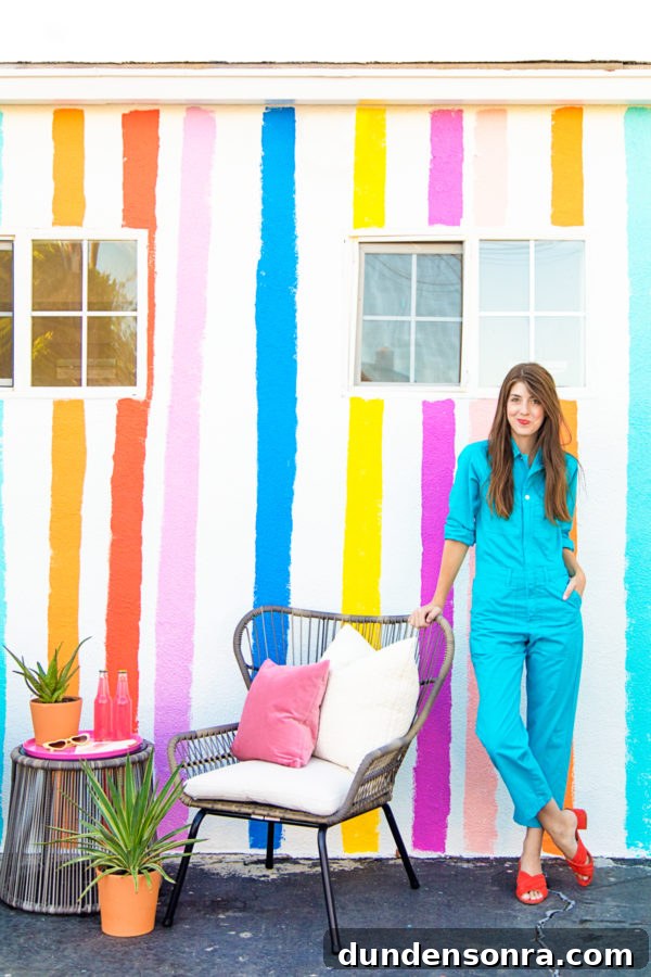 A woman standing in front of a rainbow building