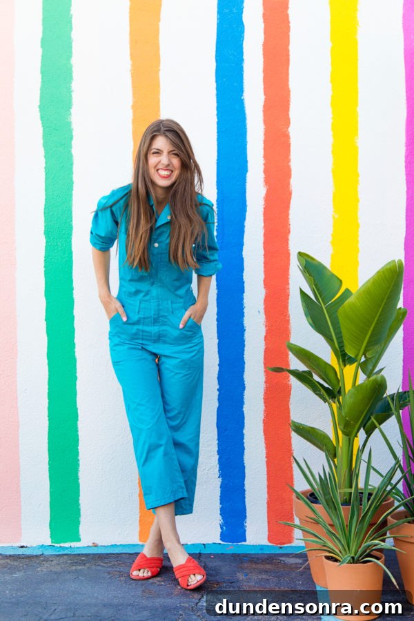 A woman standing in front of a rainbow wall