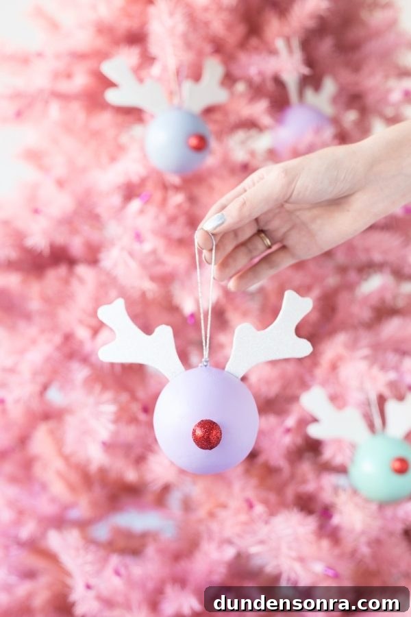 22 Festive Colorful Holiday DIYs for Bright Seasonal Decor 12 Someone holding a Rudolph ornament