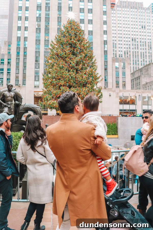 Arlo’s First Christmas in New York City: A Festive NYC Holiday Adventure 11 Two people in front of a Christmas tree
