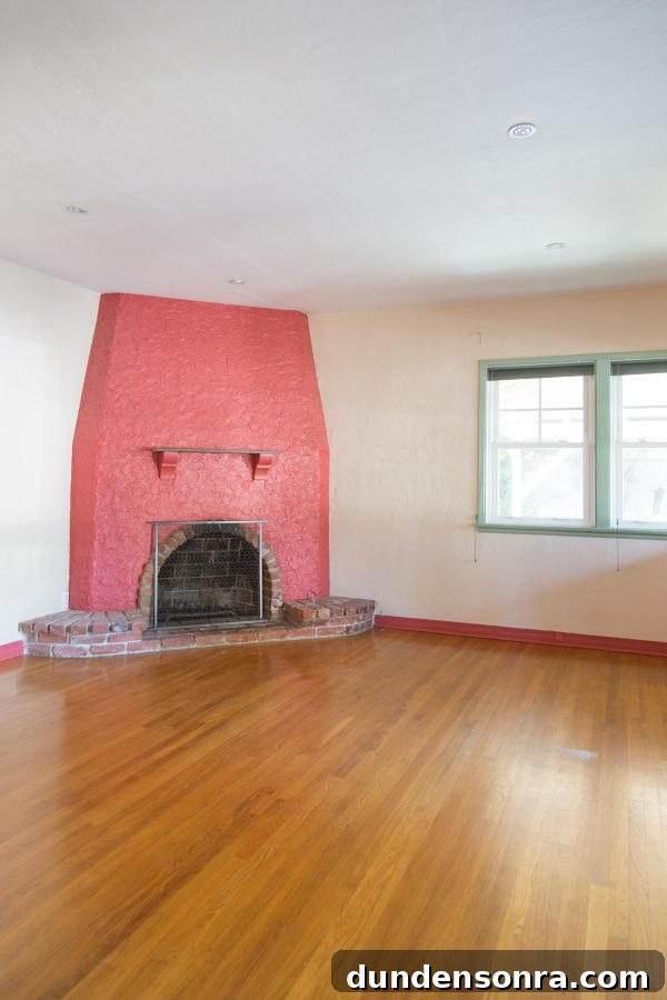 A large empty room with a pink fire place