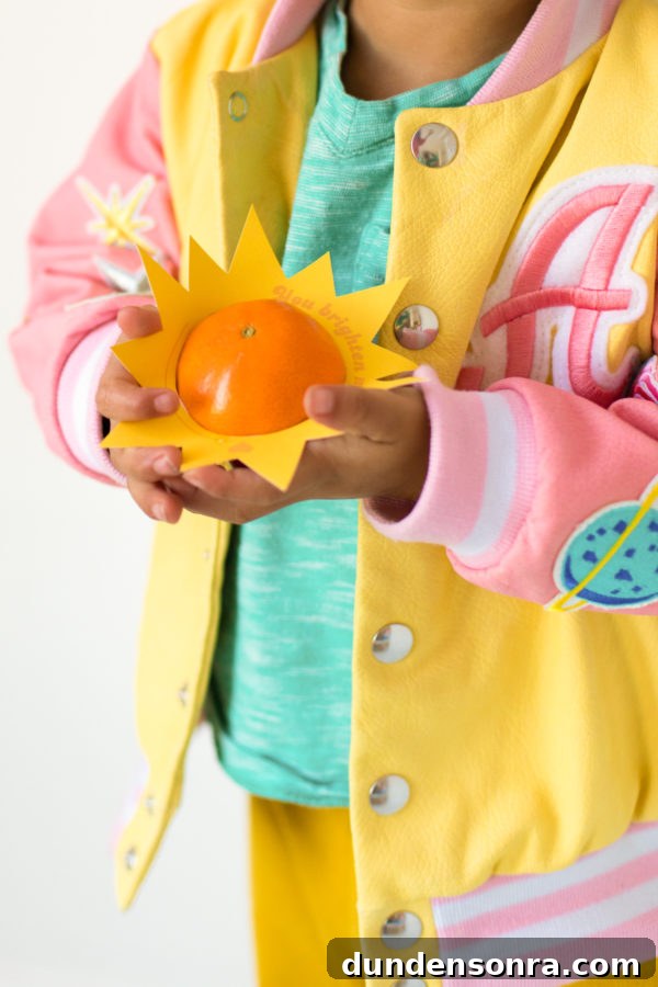 Printable Outer Space Valentines for Toddlers — DIY Cards to Make and Share 12 A person holding an orange