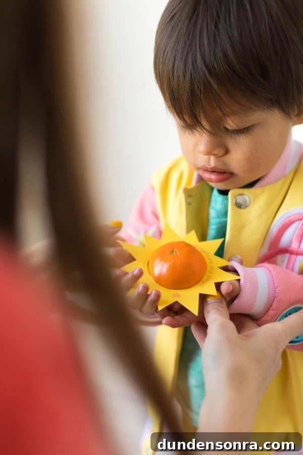 Printable Outer Space Valentines for Toddlers — DIY Cards to Make and Share 4 A small child is holding an orange