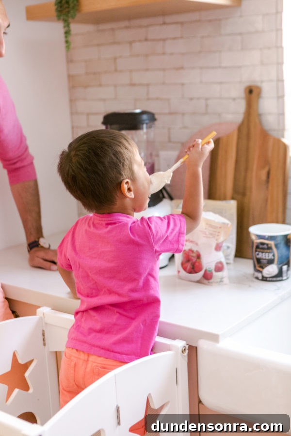 A little boy that is standing in the kitchen